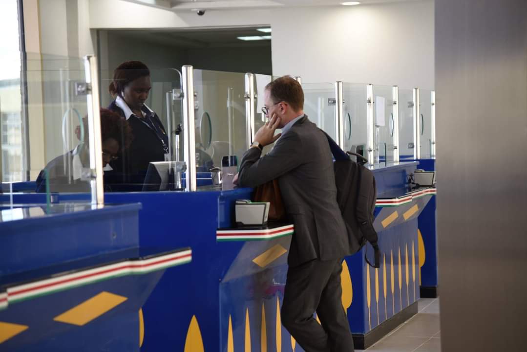 Goodlife Holidays host escorting a passenger through the departures hall at JKIA
